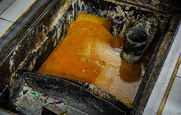 foul odors, slow draining pipes sinks, and visible grease buildup are signs that your grease trap needs cleaning